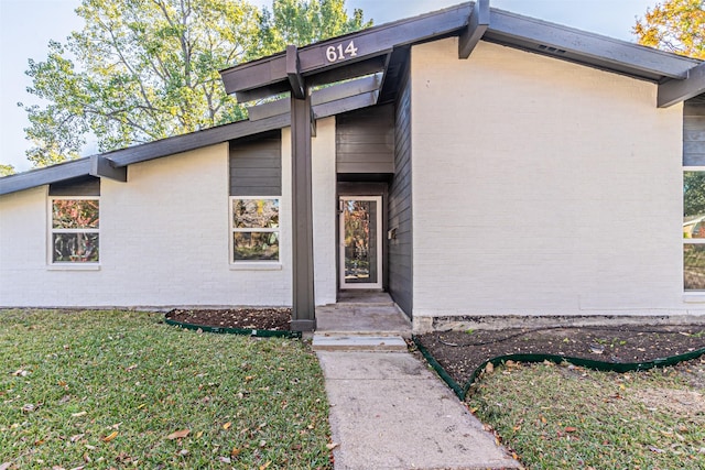 doorway to property featuring a lawn