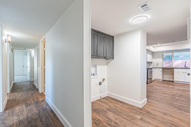 corridor with dark hardwood / wood-style flooring and sink