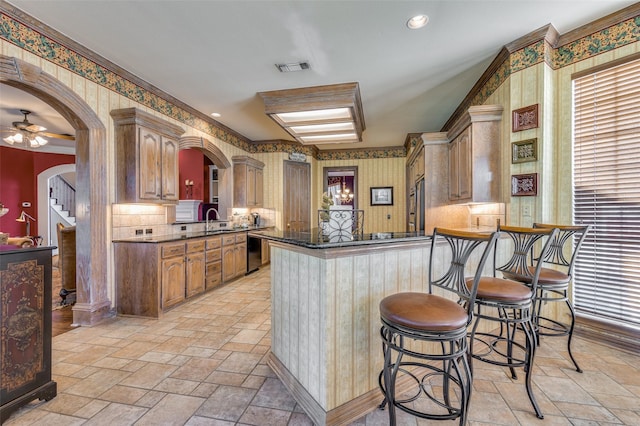 kitchen with sink, kitchen peninsula, appliances with stainless steel finishes, and a breakfast bar