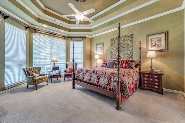 carpeted bedroom with a raised ceiling, crown molding, and ceiling fan