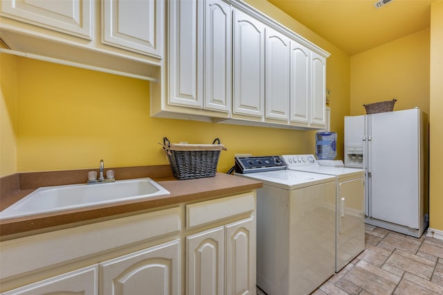 laundry area with cabinets, separate washer and dryer, and sink