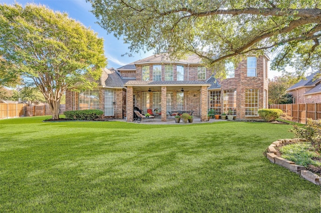 rear view of property with a yard, ceiling fan, and a patio area