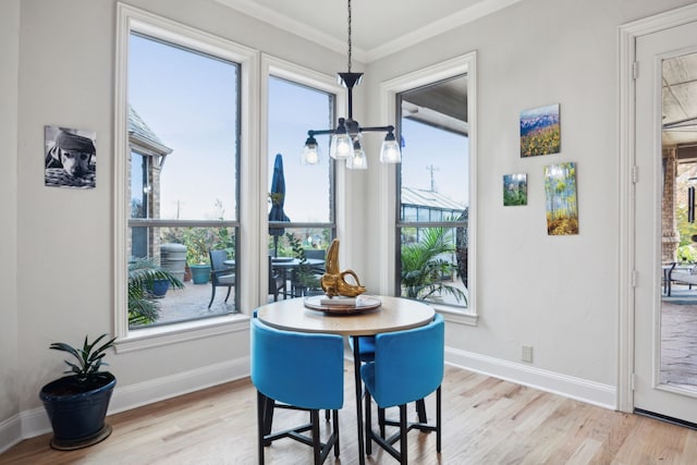 dining area featuring crown molding and light hardwood / wood-style flooring