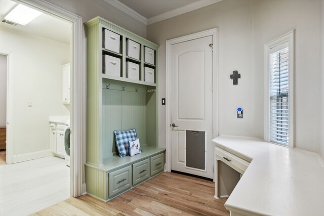 washroom featuring washing machine and clothes dryer, sink, cabinets, and light hardwood / wood-style floors