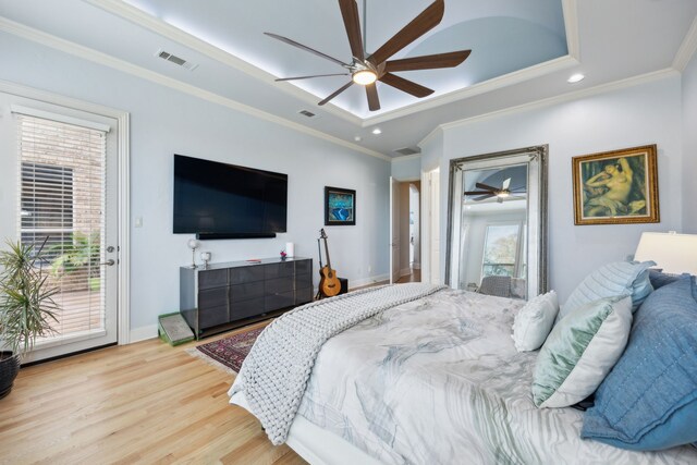 bedroom with multiple windows, a tray ceiling, ceiling fan, and ornamental molding