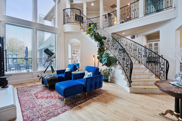 living area with stairs, wood finished floors, arched walkways, and baseboards