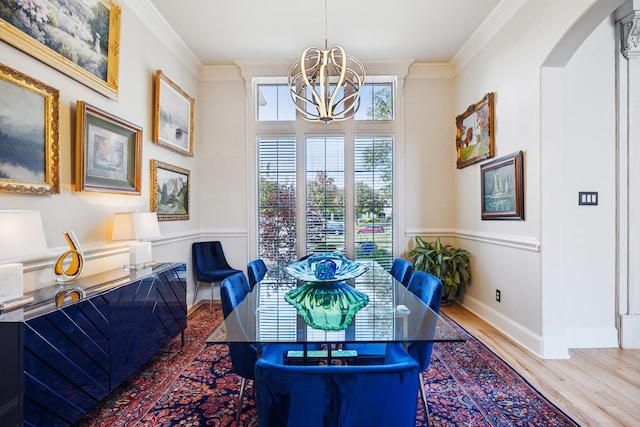 dining area featuring ornamental molding, hardwood / wood-style flooring, and a notable chandelier