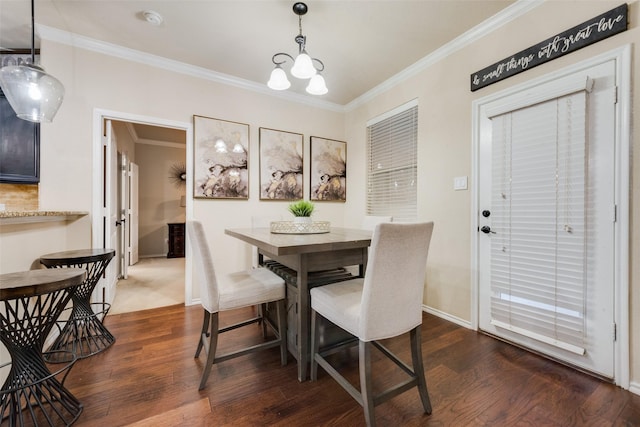 dining area featuring dark hardwood / wood-style floors, crown molding, and a notable chandelier