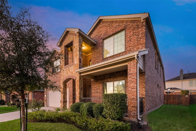 view of front of home featuring a lawn, a porch, and a garage