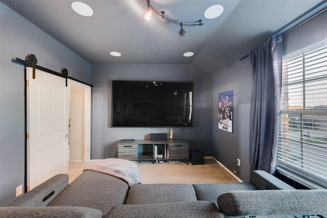 home theater room with lofted ceiling, a barn door, and carpet floors