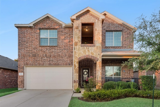 traditional-style house with brick siding, concrete driveway, covered porch, a garage, and stone siding