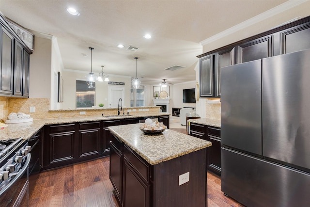 kitchen featuring dark hardwood / wood-style flooring, tasteful backsplash, stainless steel appliances, sink, and a kitchen island