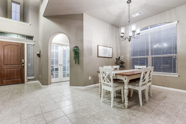 tiled dining room with french doors and an inviting chandelier