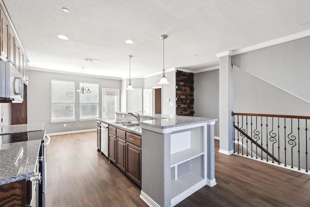 kitchen with a kitchen island with sink, light stone countertops, dark wood-type flooring, and stainless steel appliances