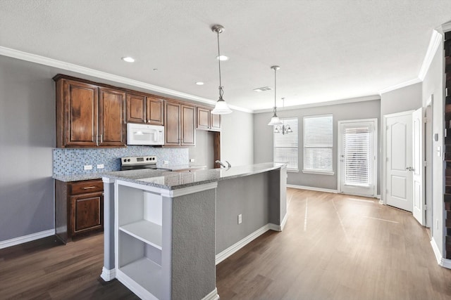 kitchen featuring pendant lighting, tasteful backsplash, a kitchen island with sink, light stone counters, and electric stove