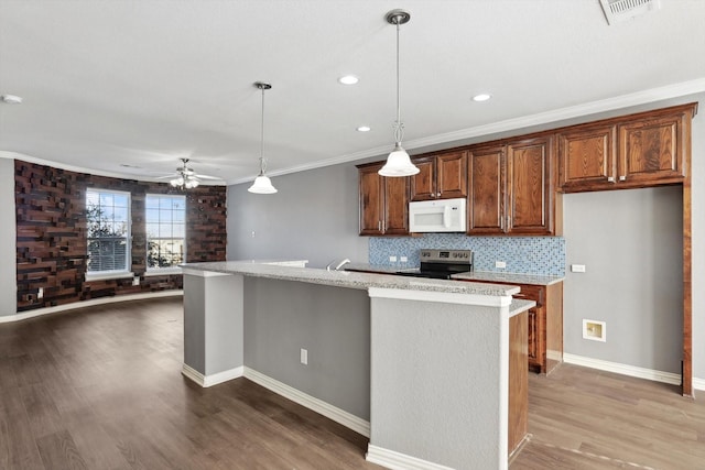 kitchen featuring dark wood-type flooring, decorative light fixtures, stainless steel electric range, and a center island with sink