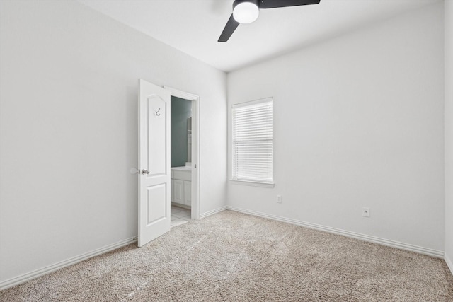 carpeted spare room featuring ceiling fan