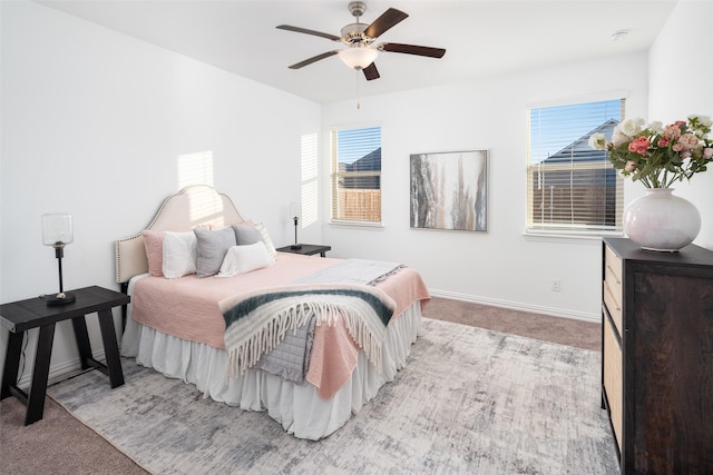 bedroom with light colored carpet, multiple windows, and ceiling fan