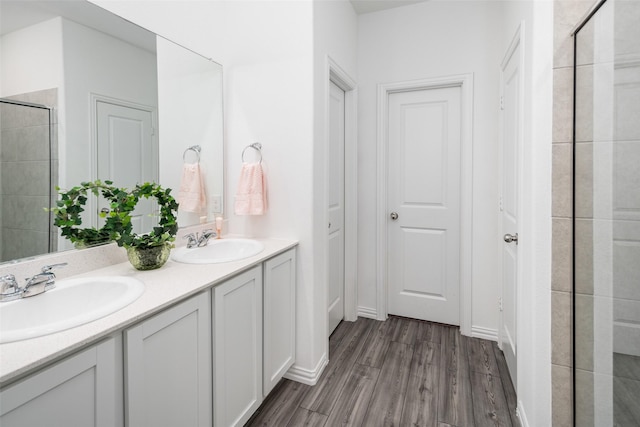 bathroom with a tile shower, vanity, and hardwood / wood-style flooring