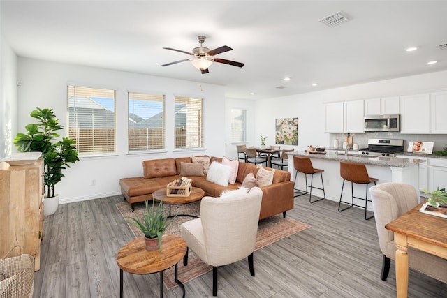 living room with ceiling fan and light hardwood / wood-style floors