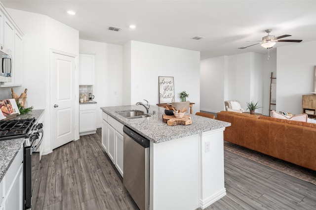 kitchen with an island with sink, stainless steel appliances, white cabinetry, and sink