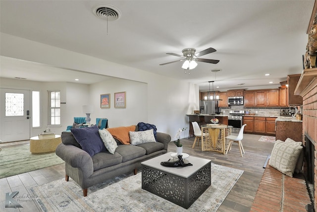 living room with light hardwood / wood-style flooring and ceiling fan