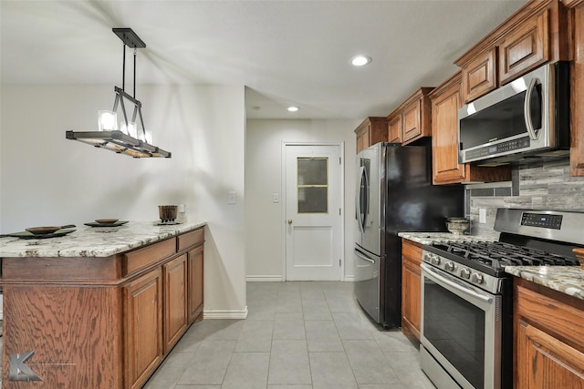 kitchen with light stone countertops, appliances with stainless steel finishes, backsplash, light tile patterned floors, and pendant lighting