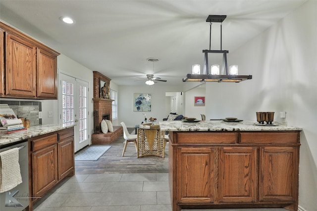 kitchen featuring ceiling fan, french doors, hanging light fixtures, stainless steel dishwasher, and hardwood / wood-style flooring