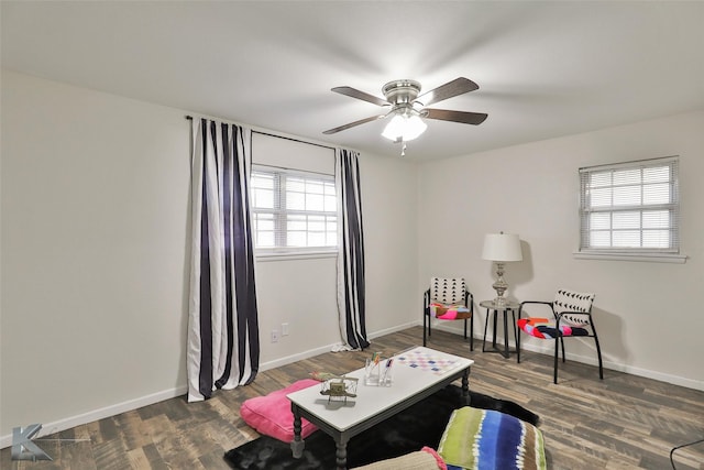 sitting room with ceiling fan, dark hardwood / wood-style flooring, and a healthy amount of sunlight