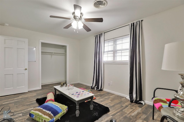 bedroom featuring ceiling fan, dark hardwood / wood-style flooring, and a closet