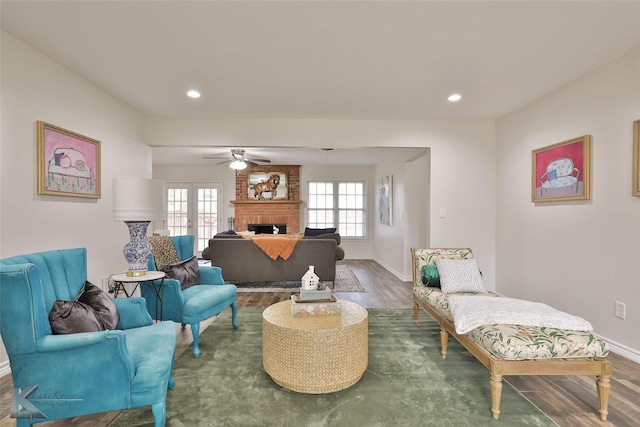 living room featuring ceiling fan, a fireplace, french doors, and hardwood / wood-style flooring