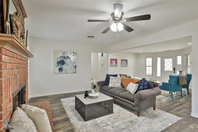 living room featuring ceiling fan, a fireplace, and dark hardwood / wood-style floors