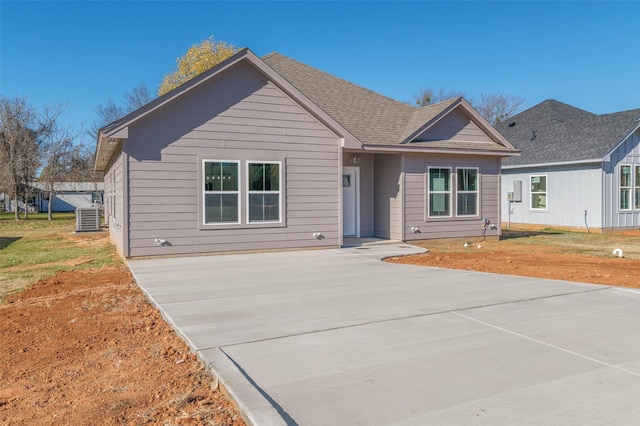 view of front of house with central AC unit and a front yard