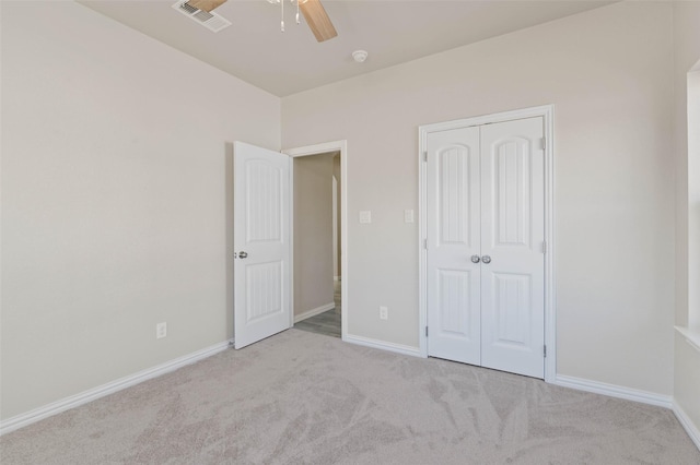 unfurnished bedroom featuring ceiling fan, light colored carpet, and a closet