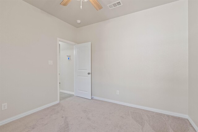 unfurnished room with light colored carpet and ceiling fan