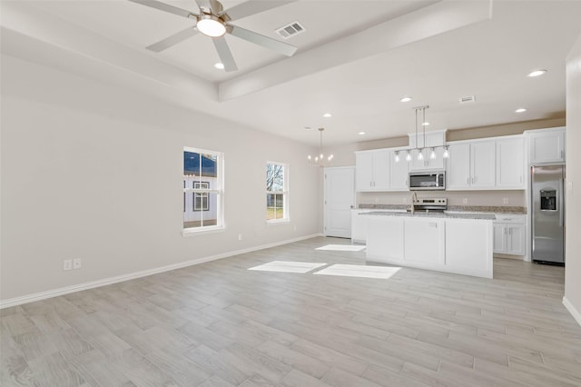 kitchen featuring a kitchen island with sink, hanging light fixtures, white cabinets, and appliances with stainless steel finishes