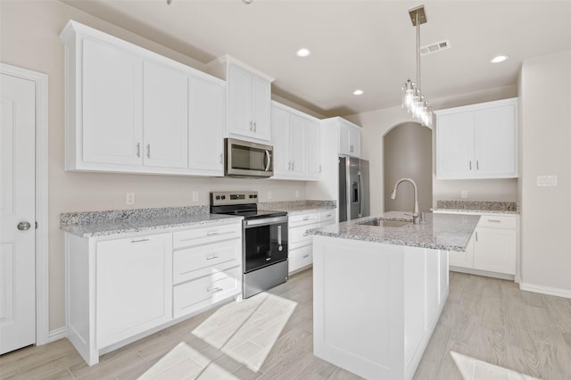 kitchen with white cabinets, sink, an island with sink, and appliances with stainless steel finishes