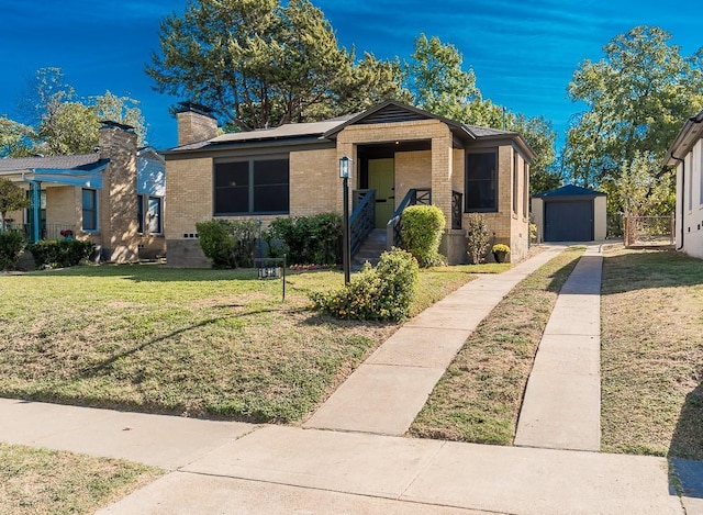 view of front of property with a garage, a front lawn, and an outdoor structure