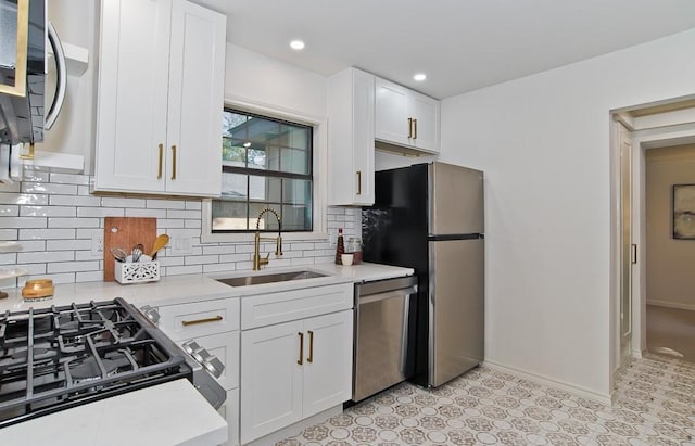 kitchen with backsplash, white cabinets, sink, light stone counters, and stainless steel appliances