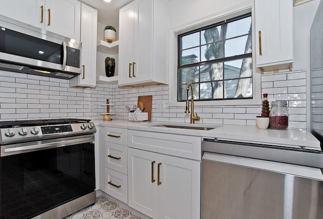 kitchen featuring appliances with stainless steel finishes, light stone countertops, sink, and white cabinets