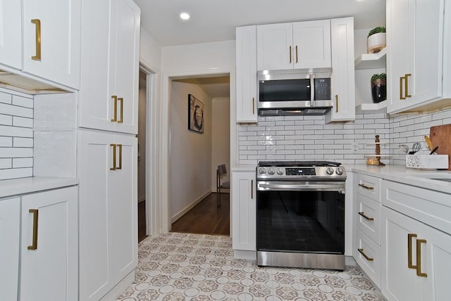 kitchen featuring white cabinets, backsplash, light stone countertops, and stainless steel appliances