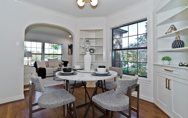 dining space with dark hardwood / wood-style floors, built in features, and crown molding