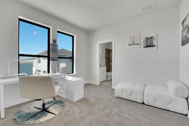 carpeted home office featuring a water view