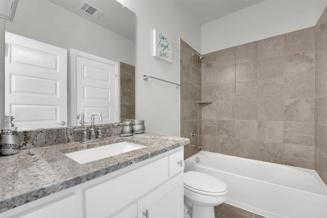 full bathroom featuring toilet, tile patterned flooring, vanity, and tiled shower / bath