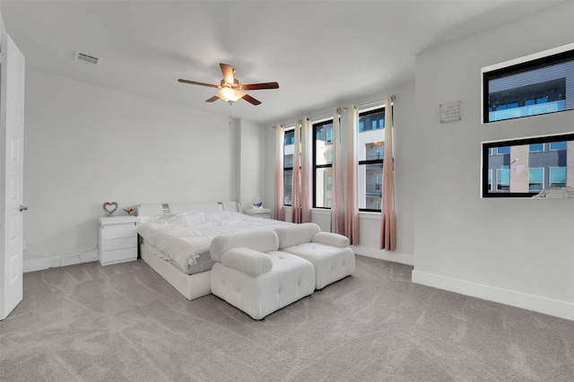 carpeted bedroom with multiple windows and ceiling fan