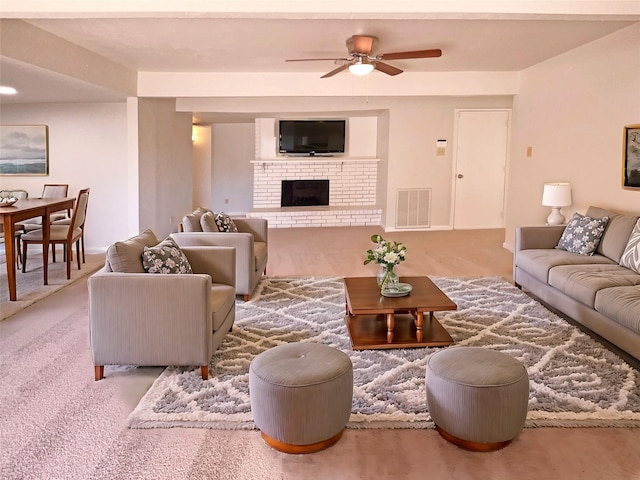 living room featuring ceiling fan, light carpet, and a brick fireplace