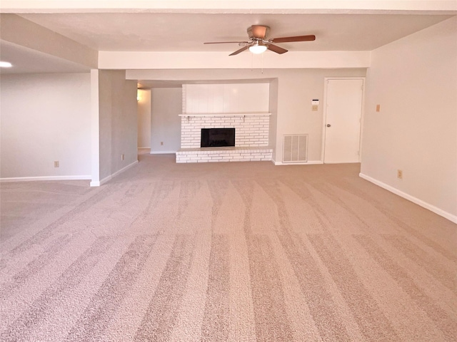 unfurnished living room featuring carpet flooring, ceiling fan, and a brick fireplace