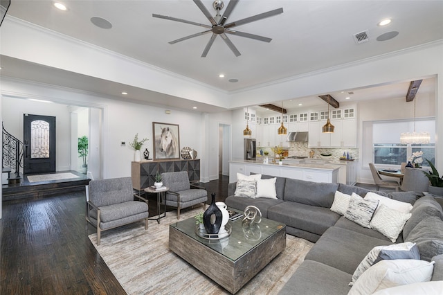 living room with ceiling fan with notable chandelier, light hardwood / wood-style floors, and crown molding