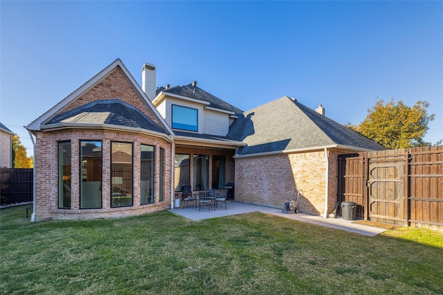 back of property featuring a lawn and a patio