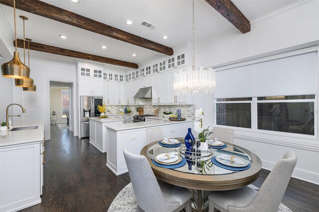 kitchen with beam ceiling, white cabinets, and stainless steel appliances